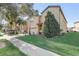 Side exterior shot of a two-story home with lush landscaping and a well-maintained lawn, with palm trees and beautiful shrubbery at 2186 Tripoli Ct, Kissimmee, FL 34747