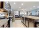 Modern kitchen featuring stainless steel appliances and granite countertops, seamlessly flowing into the cozy living room at 2186 Tripoli Ct, Kissimmee, FL 34747