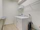 Bright laundry room with a washer, dryer, storage shelf and ironing board at 2186 Tripoli Ct, Kissimmee, FL 34747