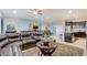 Spacious living room featuring a comfortable leather sectional, view of dining area, stairs, and a modern kitchen with dark cabinetry at 2186 Tripoli Ct, Kissimmee, FL 34747
