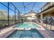Inviting screened-in pool and jacuzzi with brick surround and clear blue sky at 2186 Tripoli Ct, Kissimmee, FL 34747