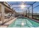 Sparkling swimming pool with screened enclosure, surrounded by lush landscaping at 2186 Tripoli Ct, Kissimmee, FL 34747