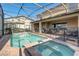 Relaxing screened-in pool and spa with brick surround, perfect for outdoor entertainment at 2186 Tripoli Ct, Kissimmee, FL 34747