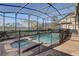 Beautiful screened-in pool and jacuzzi with brick surround and lush landscape at 2186 Tripoli Ct, Kissimmee, FL 34747