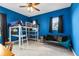 Cozy bedroom featuring vibrant blue walls, a bunk bed and futon for lounging at 2245 Bronco Dr., St Cloud, FL 34771