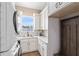Bright laundry room with white cabinetry, updated appliances, and decorative wooden hall tree at 2245 Bronco Dr., St Cloud, FL 34771