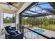 Screened in pool deck overlooking treeline with in-ground pool, hot tub, and outdoor furniture at 2245 Bronco Dr., St Cloud, FL 34771