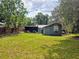The house is surrounded by lush greenery and features a screened-in patio for enjoying the outdoors at 245 S Rhodes St, Mount Dora, FL 32757