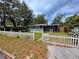 Charming single-story home featuring a quaint picket fence and an inviting screened-in porch at 245 S Rhodes St, Mount Dora, FL 32757