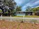 Cozy one-story home with a classic white picket fence and a relaxing screened porch at 245 S Rhodes St, Mount Dora, FL 32757