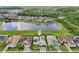 Aerial view of a stunning home with beautiful landscaping, a pond view, and a screened-in patio at 2586 Lancaster Ridge, Davenport, FL 33837