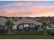 Stunning aerial view showcasing the home's screened-in patio in a lush neighborhood at sunset at 2586 Lancaster Ridge, Davenport, FL 33837