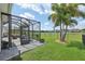 Enjoy the beautiful view and outdoor dining in this screened-in patio with a green lawn at 2586 Lancaster Ridge, Davenport, FL 33837