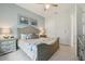 Comfortable bedroom with a wooden bed frame and blue accent wall, with decor and ensuite bath at 2586 Lancaster Ridge, Davenport, FL 33837