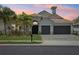 Charming single-Gathering home featuring a three-car garage, lush landscaping, and a well-manicured lawn at sunset at 2586 Lancaster Ridge, Davenport, FL 33837
