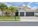 Beautiful single-Gathering home showcasing a well-manicured lawn, a three-car garage, and lovely landscaping at 2586 Lancaster Ridge, Davenport, FL 33837