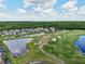 Aerial view of an expansive golf course community with mature trees, a lake and manicured green fairways at 2586 Lancaster Ridge, Davenport, FL 33837