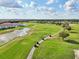 Beautiful aerial view of golfers on a lush green golf course with ponds, mature trees and golf carts at 2586 Lancaster Ridge, Davenport, FL 33837