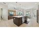 Open-concept kitchen and living area with a large center island, stainless steel appliances, and modern lighting at 2586 Lancaster Ridge, Davenport, FL 33837