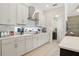 Bright kitchen with white cabinetry, modern appliances, and a window overlooking the backyard, flowing into living area at 2586 Lancaster Ridge, Davenport, FL 33837