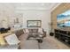 Open-concept living area adjacent to the kitchen featuring an accent wall, large sectional sofa, and modern decor at 2586 Lancaster Ridge, Davenport, FL 33837