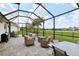 The screened-in lanai offers views of the water, comfortable seating and stylish pavers at 2586 Lancaster Ridge, Davenport, FL 33837