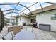 Screened-in patio boasts comfortable seating, an outdoor grill, and tiled flooring for relaxed outdoor living at 2586 Lancaster Ridge, Davenport, FL 33837