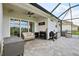 The covered lanai features an outdoor kitchen, comfortable couch, ceiling fan and stylish pavers at 2586 Lancaster Ridge, Davenport, FL 33837