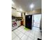 Bright kitchen features white appliances, stylish cabinets, tiled flooring, and convenient access to an outdoor patio at 2716 Upsandown St, Orlando, FL 32837