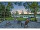 Paver patio with fire pit and seating overlooks a tranquil lake and dock with gazebo at 277 Sunrise Pt, Lake Mary, FL 32746