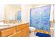 Bathroom with wood cabinets and a shower with a blue ocean-themed shower curtain at 2805 Lido Key Ct, Kissimmee, FL 34747