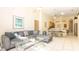 Bright living room featuring tiled floors, a comfortable gray sectional, and an adjacent dining area at 2805 Lido Key Ct, Kissimmee, FL 34747