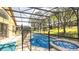 A covered pool in the backyard, with lawn chairs, and a screened-in patio at 2805 Lido Key Ct, Kissimmee, FL 34747