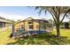 Exterior backyard showing a pool and a screened in patio with a grassy lawn at 2805 Lido Key Ct, Kissimmee, FL 34747