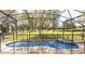 Backyard with an enclosed pool, green grass, and mature trees at 2805 Lido Key Ct, Kissimmee, FL 34747