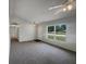 Spacious living room with neutral walls, plush carpet, and large window with outdoor views at 3090 Yorkshire Dr, Deltona, FL 32738