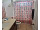 Bright bathroom featuring a sink, toilet, and patterned shower curtain at 3265 Stratton Cir, Kissimmee, FL 34744