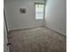 This bedroom features neutral walls, carpeting, and a window letting in natural light at 3265 Stratton Cir, Kissimmee, FL 34744