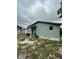 Exterior view of the back of the light green house with a window and a sliding glass door at 332 S Observatory Dr, Orlando, FL 32835