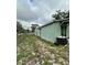 Exterior view of light green house with an air conditioning unit in the backyard at 332 S Observatory Dr, Orlando, FL 32835