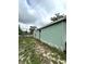 A view of the side of the exterior of the house featuring light green siding at 332 S Observatory Dr, Orlando, FL 32835