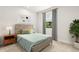A cozy bedroom with a large window, green and yellow bedding, and a wooden nightstand at 3635 Arbordale Loop, Sanford, FL 32771