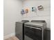 Well-lit laundry area featuring gray washer and dryer with shelving and supplies for convenient chores at 3635 Arbordale Loop, Sanford, FL 32771