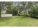 Expansive green backyard enclosed by a white fence and lush trees offering privacy and space at 394 Hickory Springs Pl, Debary, FL 32713
