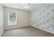 Bedroom with large window, chevron accent wall, and carpet flooring at 394 Hickory Springs Pl, Debary, FL 32713