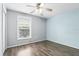Bedroom with wood-look floors, a window, and light blue accent wall at 394 Hickory Springs Pl, Debary, FL 32713