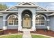 Inviting home entrance featuring a covered porch, double doors, and arched windows with decorative shutters at 394 Hickory Springs Pl, Debary, FL 32713