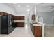 Kitchen with stainless steel appliances, tiled flooring, dark cabinets and arched entryways at 394 Hickory Springs Pl, Debary, FL 32713