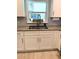 Well-lit kitchen with white cabinets, granite countertops, stainless steel sink, and a decorative window at 415 Seville Ave, Altamonte Springs, FL 32714