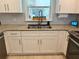 Well-lit kitchen with white cabinets, granite countertops, stainless steel sink, and a decorative window at 415 Seville Ave, Altamonte Springs, FL 32714